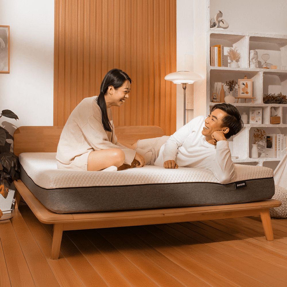 Couple enjoying comfort on Sonno wooden bed frame with Japandi design, featuring eco-friendly materials and modern aesthetics.