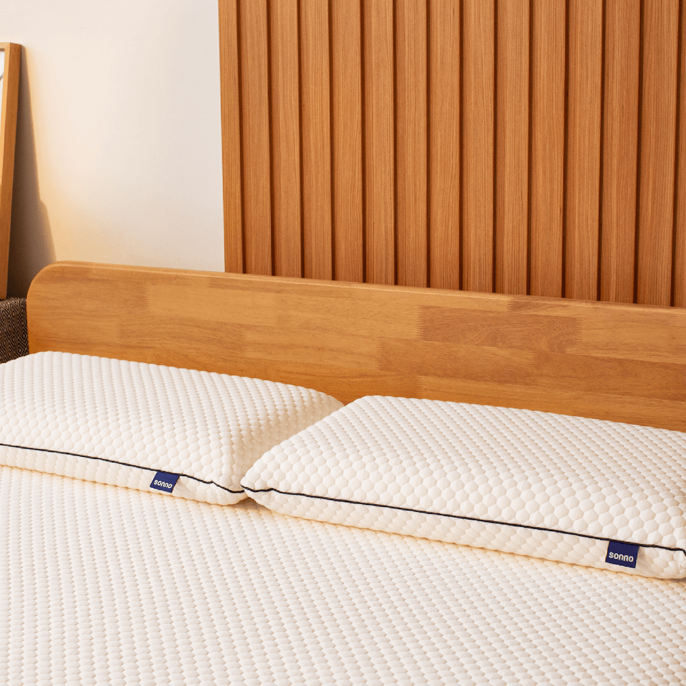 Sonno pillow with memory foam for ergonomic support on a wooden bed frame.