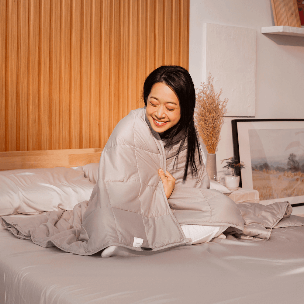 Woman enjoying the cozy and calming effects of the Sonno weighted blanket, ideal for anxiety relief and better sleep.